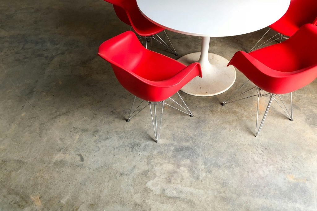 An office table surrounded by red chairs